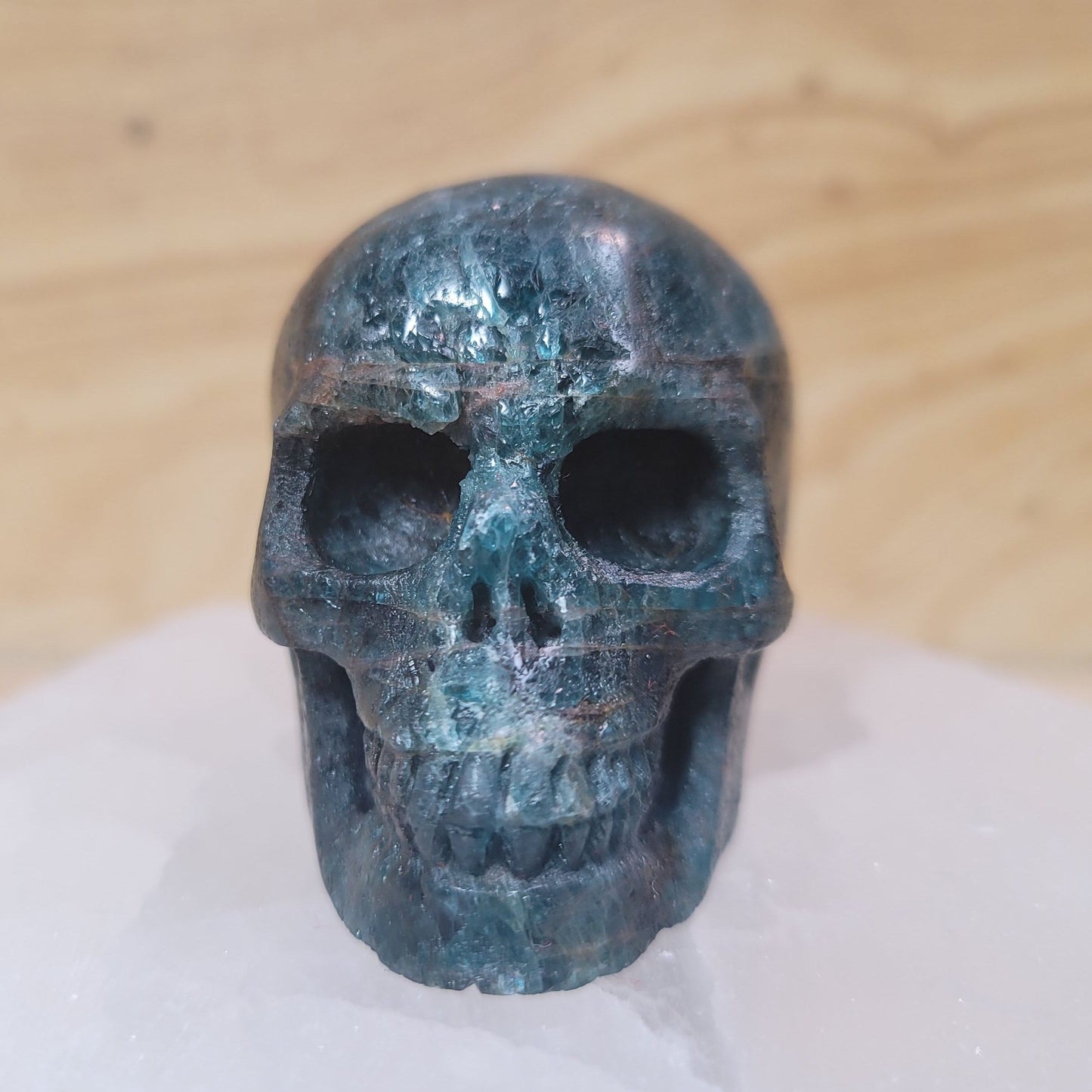 A beautifully crafted Blue Apatite Skull, showcasing its vibrant blue hues and intricate details, set against a soft, neutral background. This unique piece represents both artistic expression and the metaphysical properties of blue apatite, including mental clarity and enhanced communication.