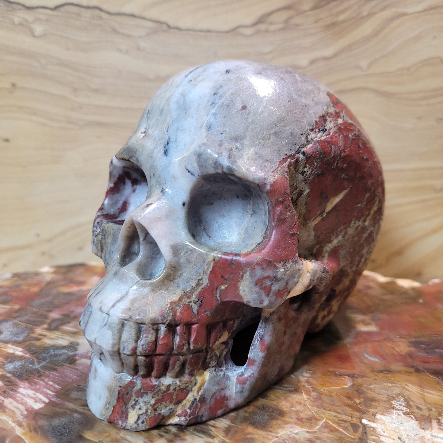A unique and beautiful hand carved piece made from Brecciated Jasper. This Skull is 5" tall (from top to bottom) and weighs approximately 2 pounds 13.1 ounces. Brecciated Jasper is a form of Chalcedony, formed from fragments of rock that have been cemented together over time. This process creates its beautiful, layered appearance, making each piece truly one-of-a-kind. Brecciated Jasper is renowned for its ability to ground and stabilize the energy of the wearer. It helps to co