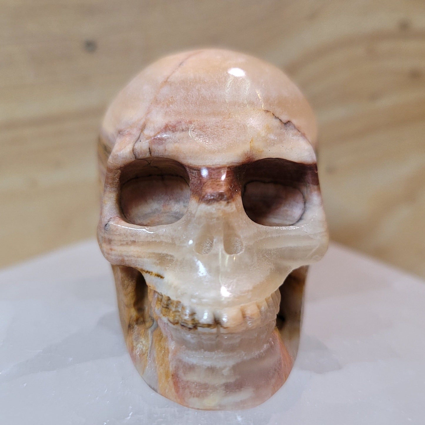 A beautifully carved Afghanistan jade skull featuring rich green tones and intricate patterns, displayed on a soft, neutral background. This unique piece symbolizes emotional healing, harmony, and wisdom, making it a striking decorative item.