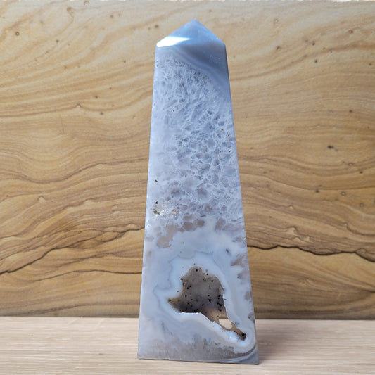 A stunning Agate Druzy Tower, showcasing layers of agate with sparkling druzy crystals and intricate patterns, displayed against a soft, neutral background. This elegant piece symbolizes stability and growth, making it a captivating decorative item.