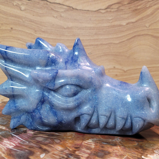 A stunning Blue Aventurine Dragon Figurine, measuring 5 to 8 inches tall, showcasing gentle blue hues and intricate carvings, displayed against a soft, neutral background. This unique piece symbolizes strength and transformation, making it a captivating decorative item.