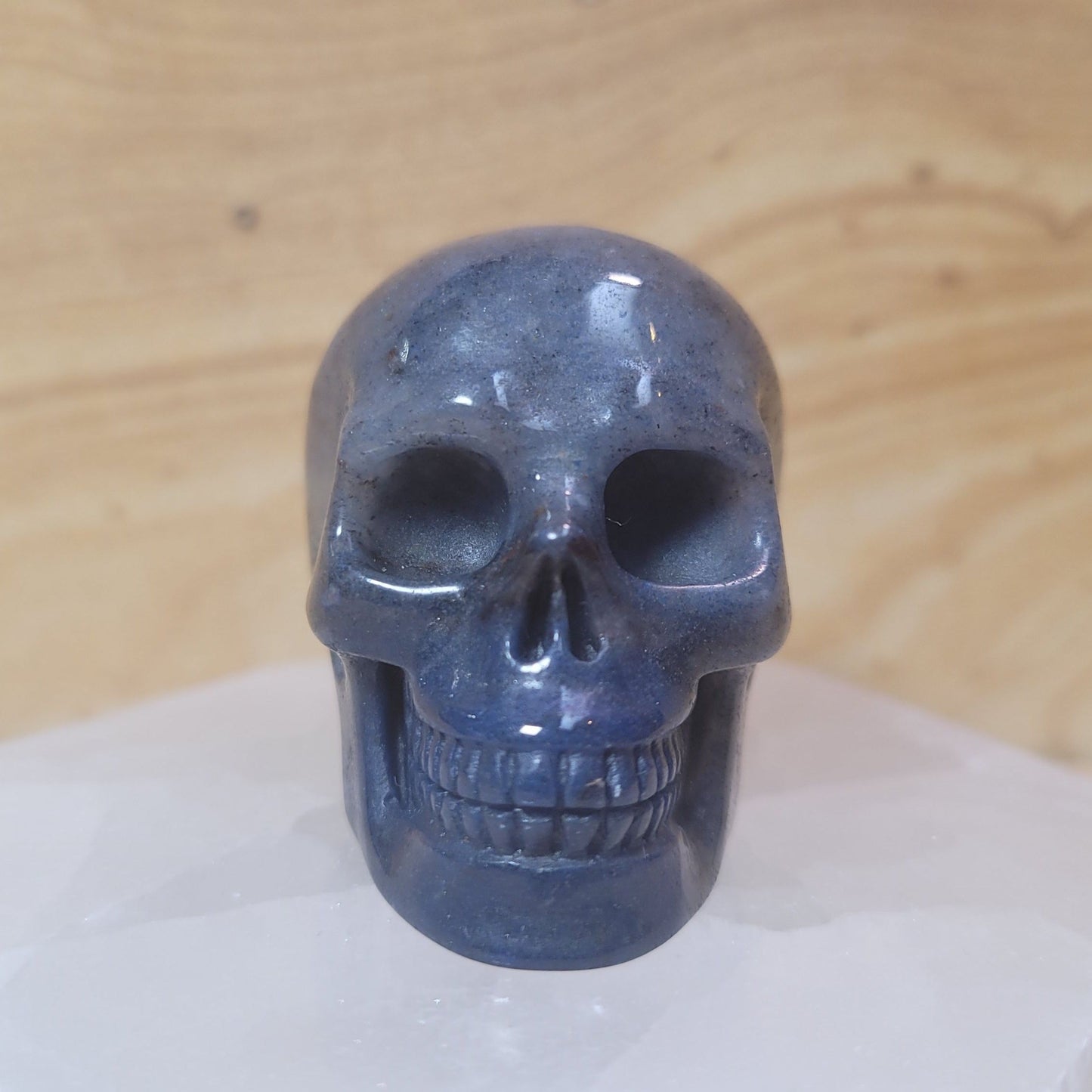 A beautifully hand-carved Blue Aventurine Skull, measuring 2 inches tall and weighing approximately 3.1 ounces, showcasing gentle blue tones and a shimmering effect, displayed against a soft, neutral background.