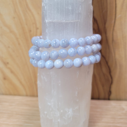 A delicate 8mm Blue Lace Agate Bracelet featuring soft blue beads with intricate lace-like patterns, displayed against a soft, neutral background. This elegant piece symbolizes calmness, emotional healing, and effective communication, making it a beautiful accessory.