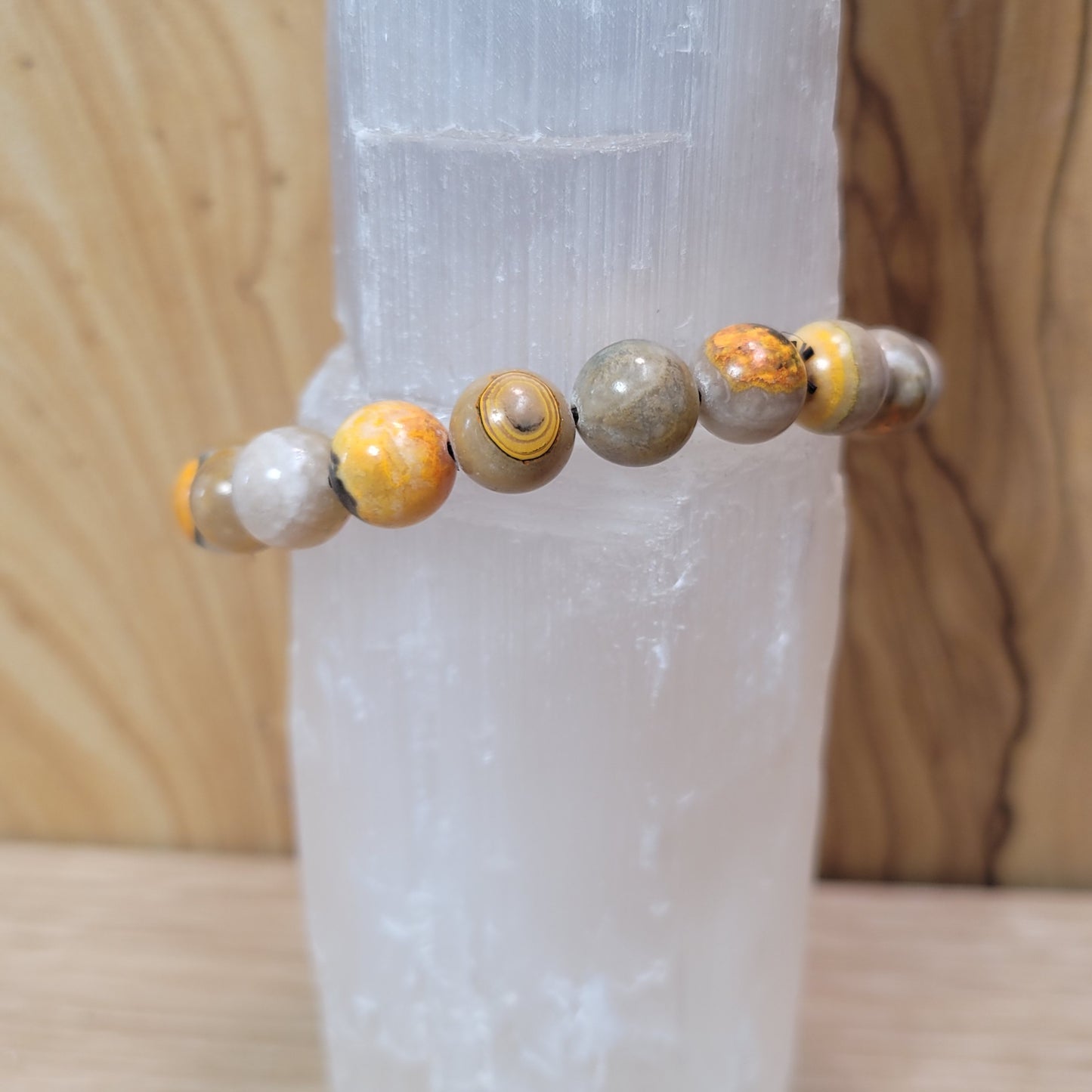 9.5mm bumblebee jasper bracelet featuring vibrant yellow, orange, and black beads, known for its creativity, energy, and emotional balance metaphysical properties.