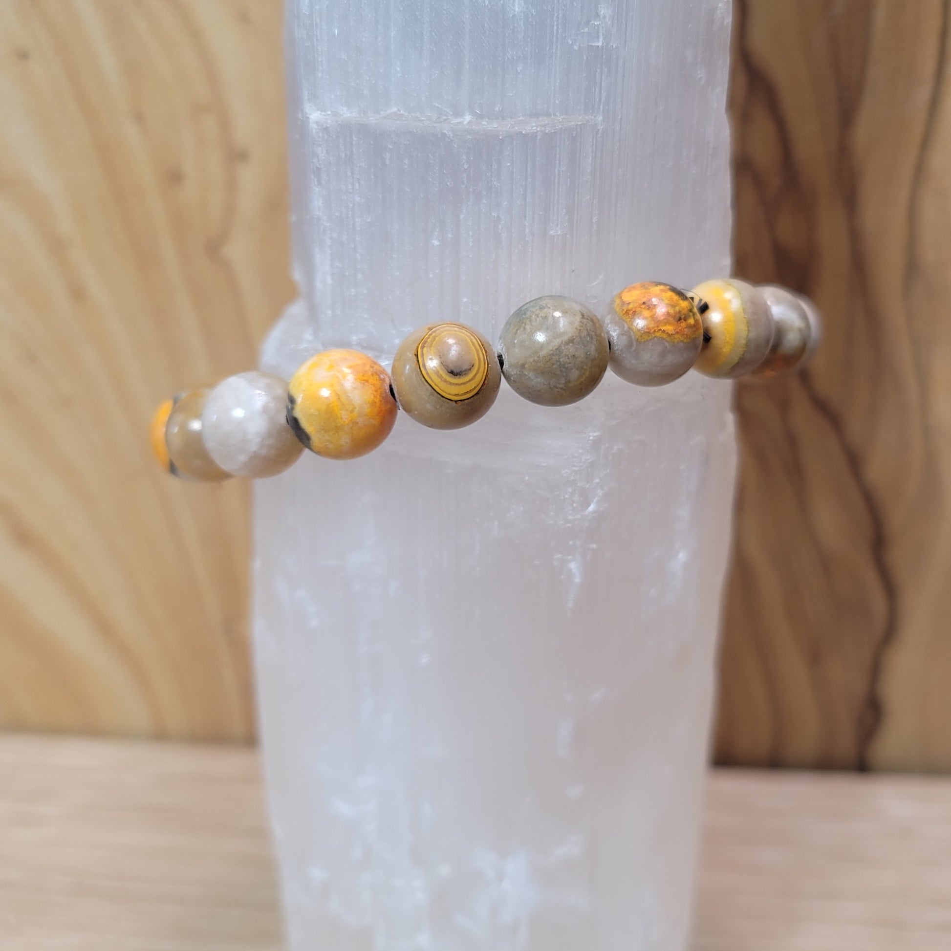 9.5mm bumblebee jasper bracelet featuring vibrant yellow, orange, and black beads, known for its creativity, energy, and emotional balance metaphysical properties.