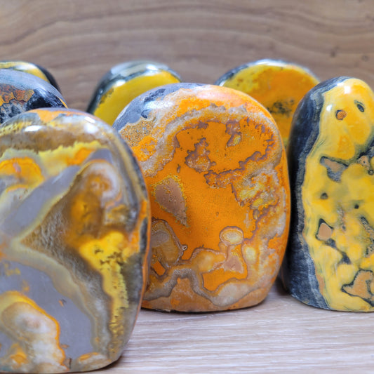 Bumblebee jasper freeform featuring bright yellow, orange, and black patterns, known for its creativity, energy, and emotional balance metaphysical properties.