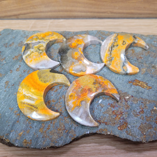 Bumblebee jasper moons featuring bright yellow, orange, and black patterns, known for its creativity, energy, and emotional balance metaphysical properties.