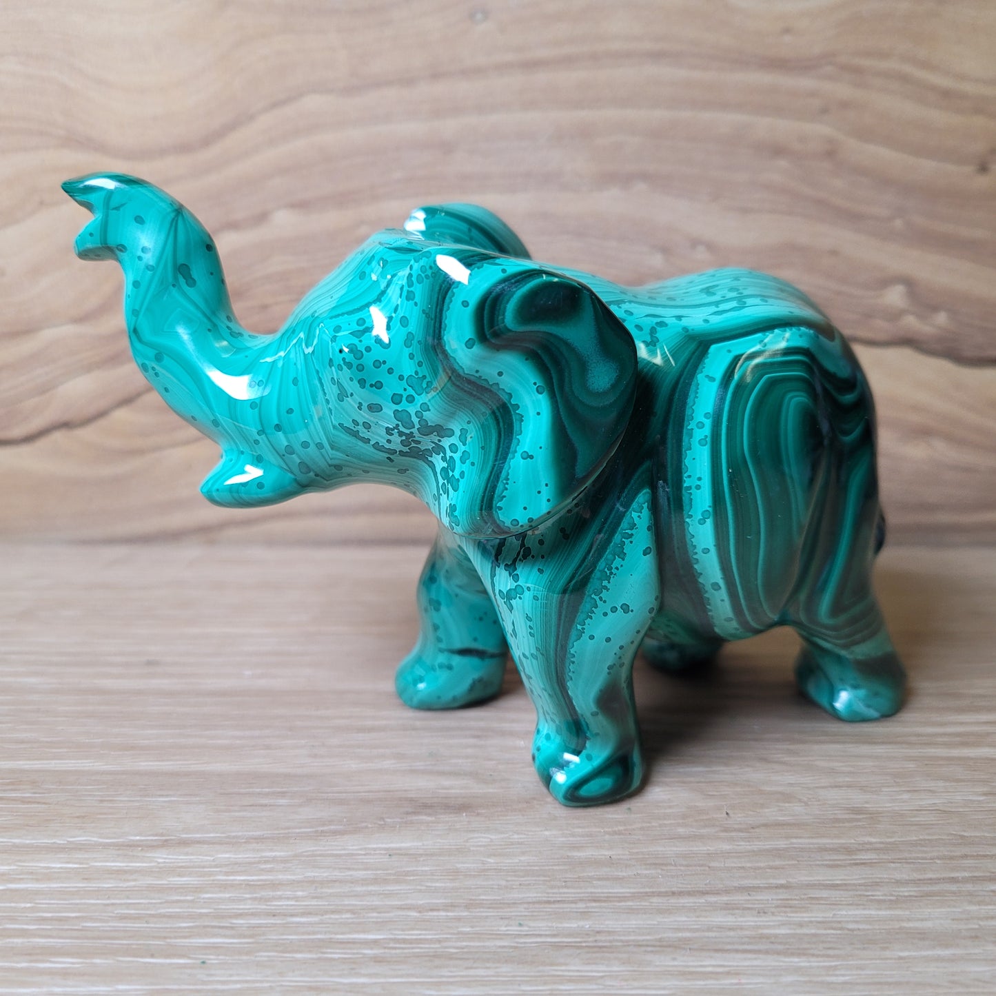Green Malachite elephant figurine on a wooden surface