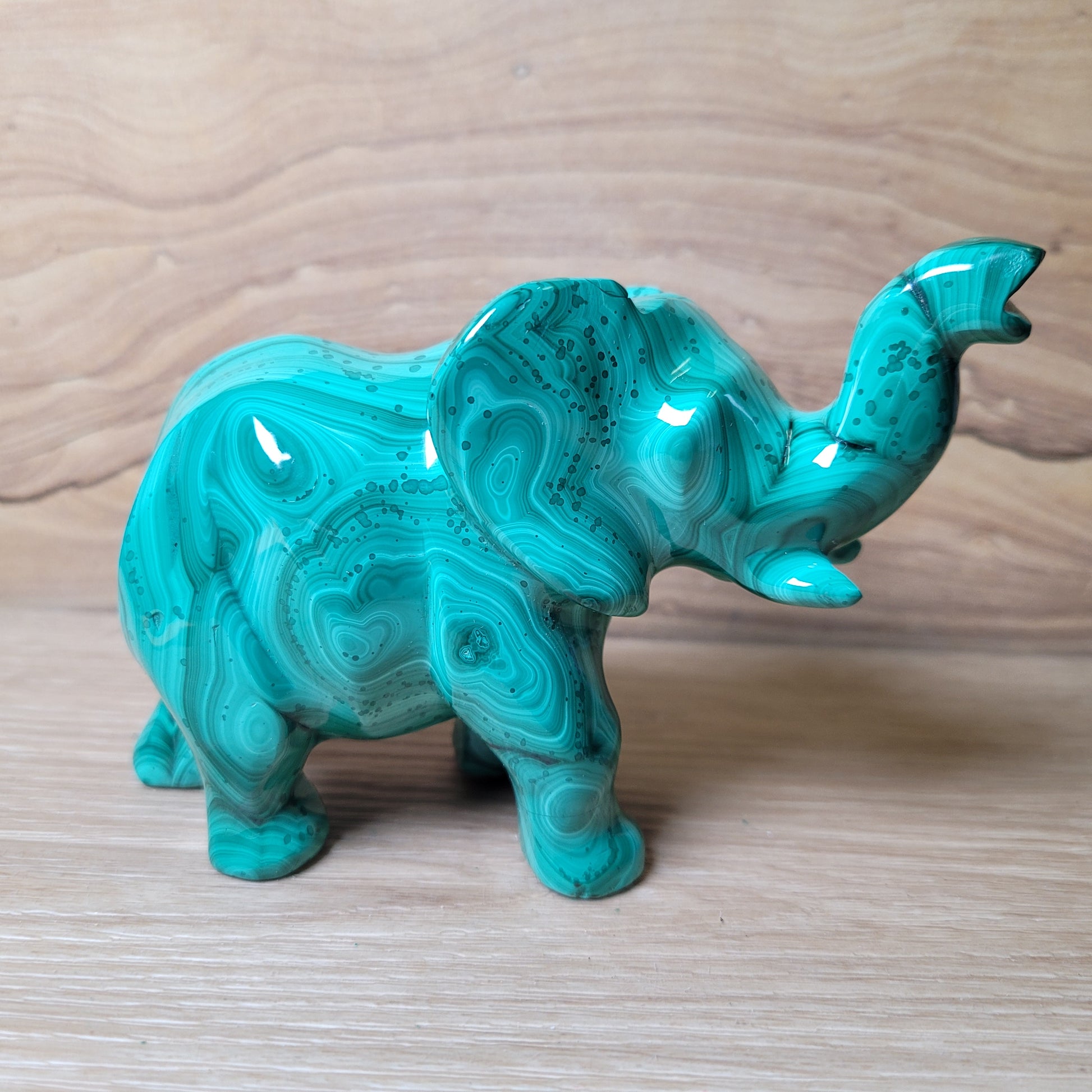 Green Malachite elephant figurine on a wooden surface