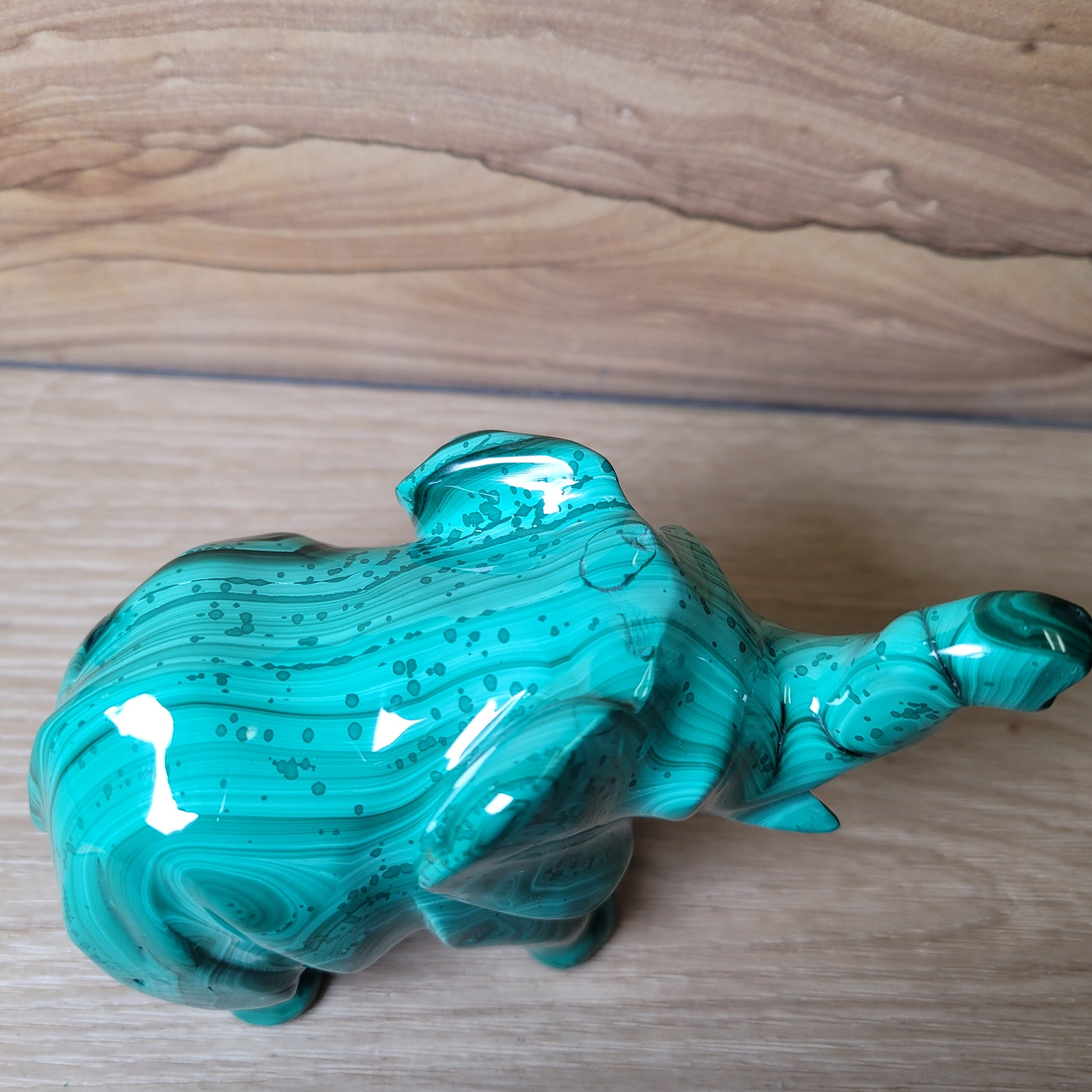 Green Malachite elephant on a wooden surface
