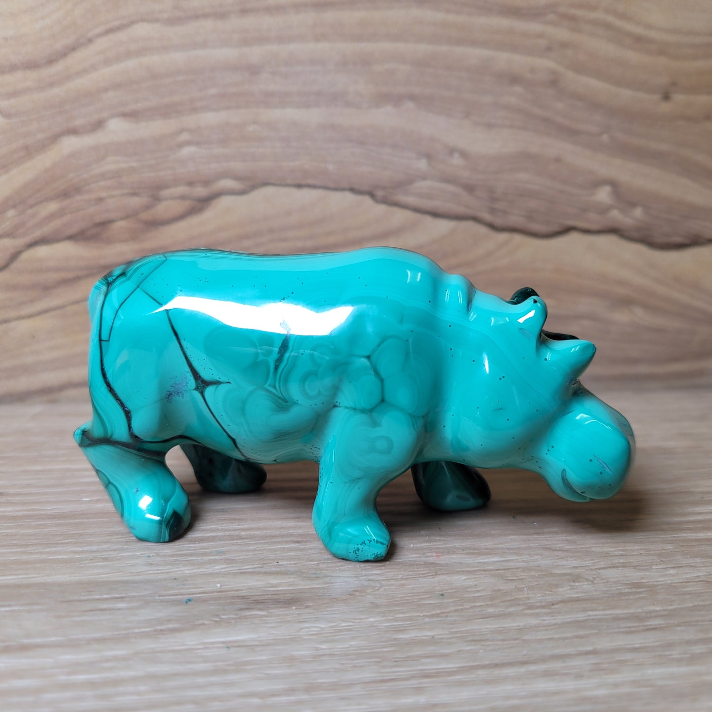 Green Malachite Hippopotamus figurine on a wooden surface