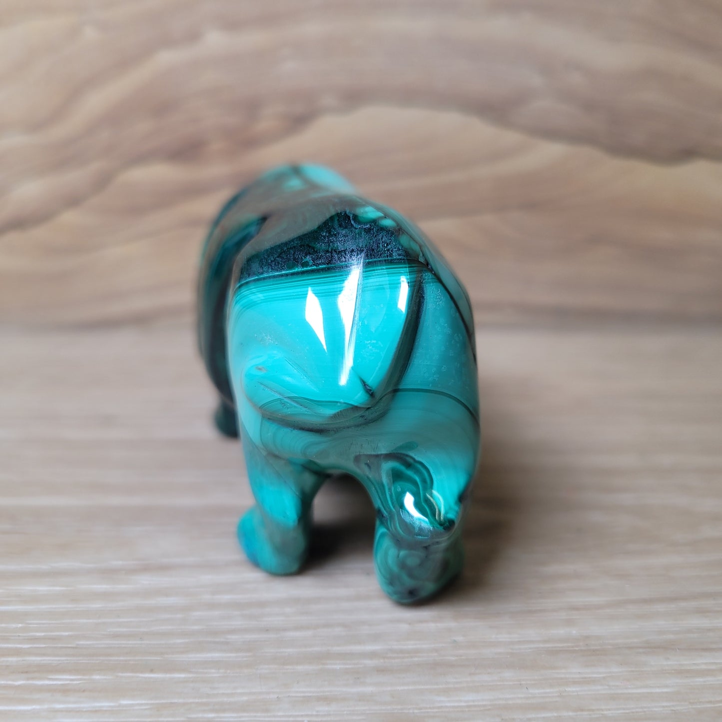 Green Malachite Hippopotamus figurine on a wooden surface