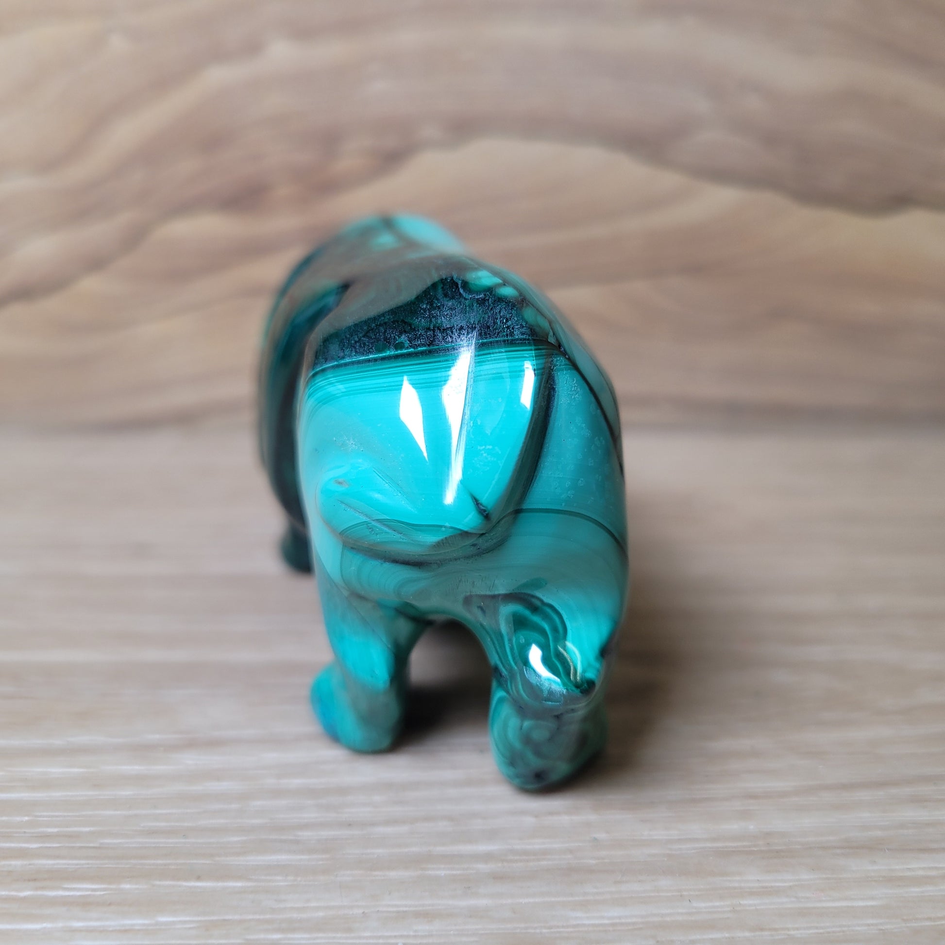 Green Malachite Hippopotamus figurine on a wooden surface