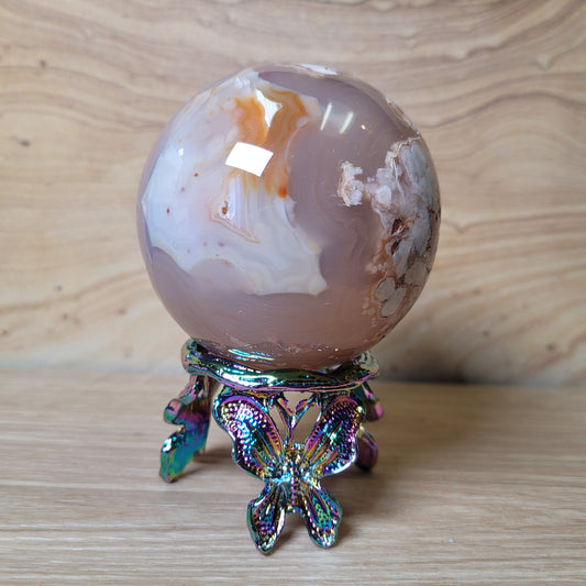 Decorative crystal ball on a metallic stand against a wooden background