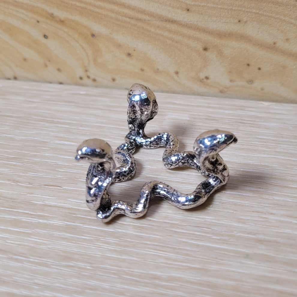 Silver snake-shaped design on a wooden surface